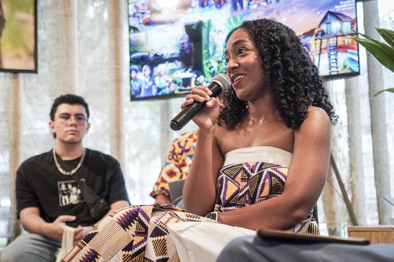 Mujer afro lidera la conversación en el panel de expertos. Auditorio lleno