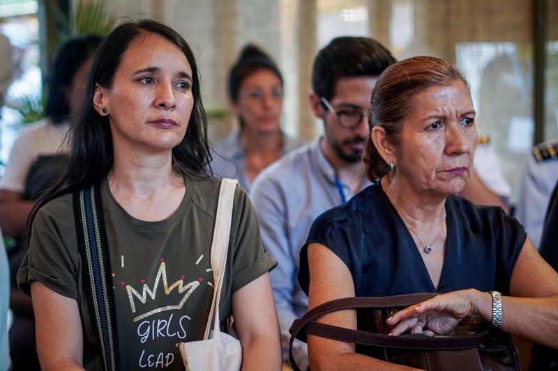 Dos mujeres, de diferentes edades, atentas a los temas que se exponen en el conversatorio sobre kit ambiental