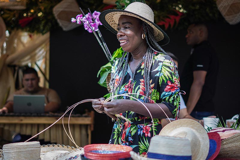 Mujer afro, entrelazando caña para crea artesanias como parte de la economía popular.