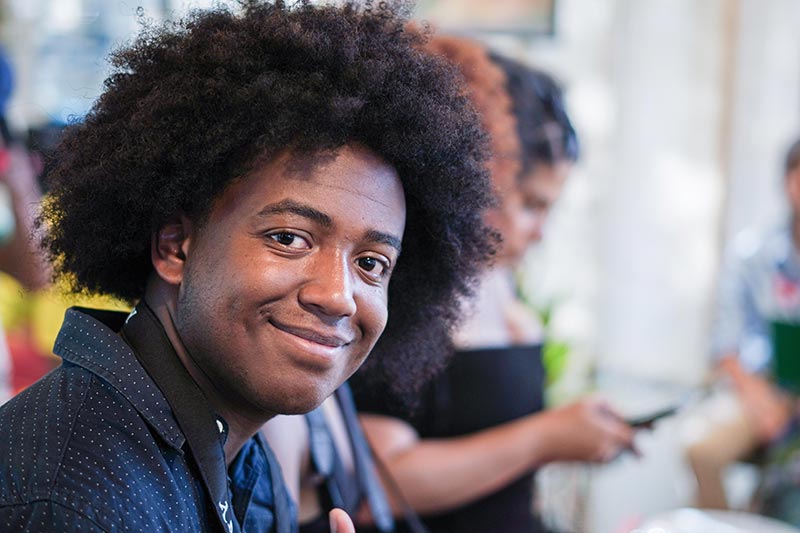 Hombre afro sonríe, feliz  por participar en  las charlas programadas por el DNP.