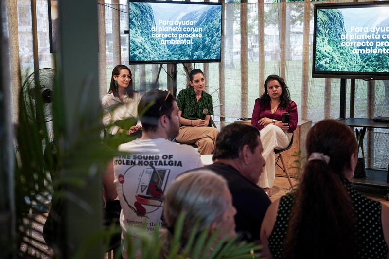 Tres mujeres sentadas frente a una audiencia en una sesión sobre procesos ambientales.