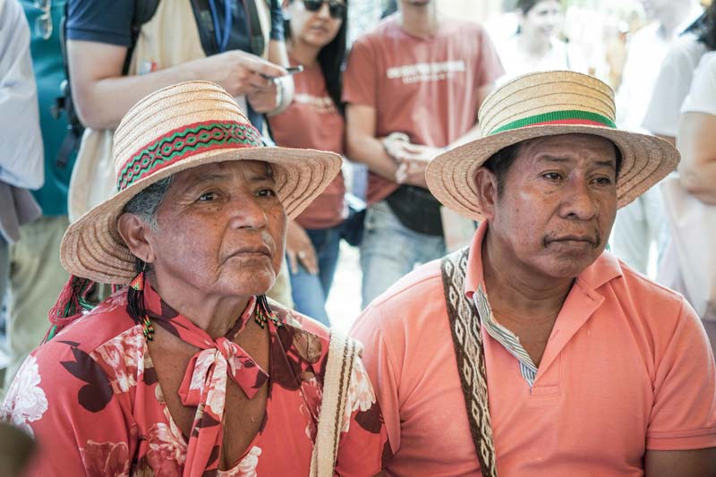 Dos campesinos, hombre y mujer visten sombrero y mochila. Concentrados en la charla.