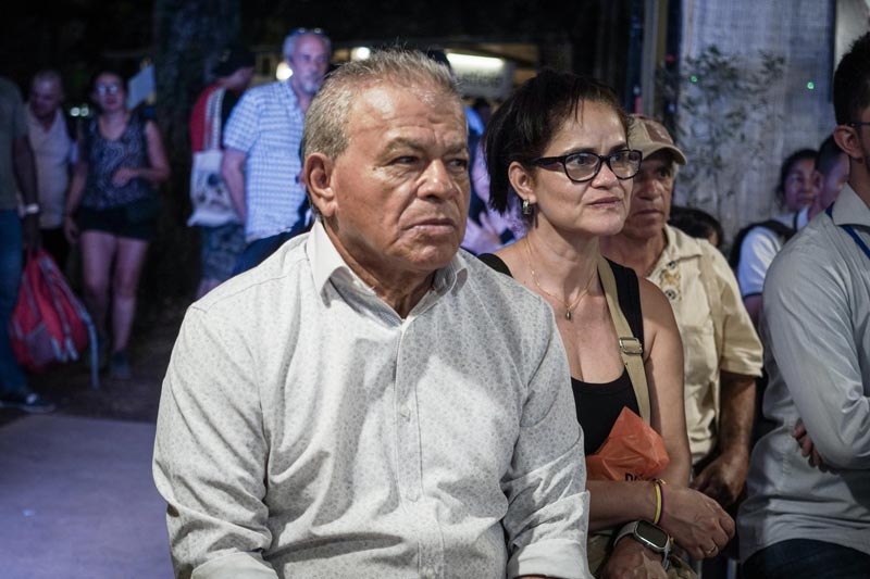  Hombre mayor está sentando con camisa blanca prestando atención a una charla. 